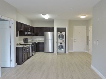 an empty kitchen with a washing machine and a refrigerator
